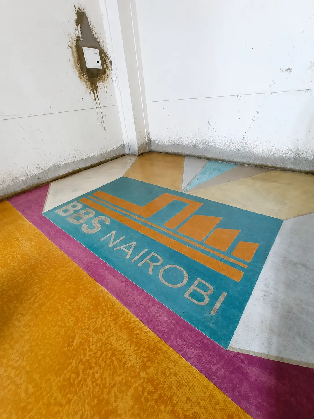 Second orange custom-branded terrazzo floor feature in a finished doorway