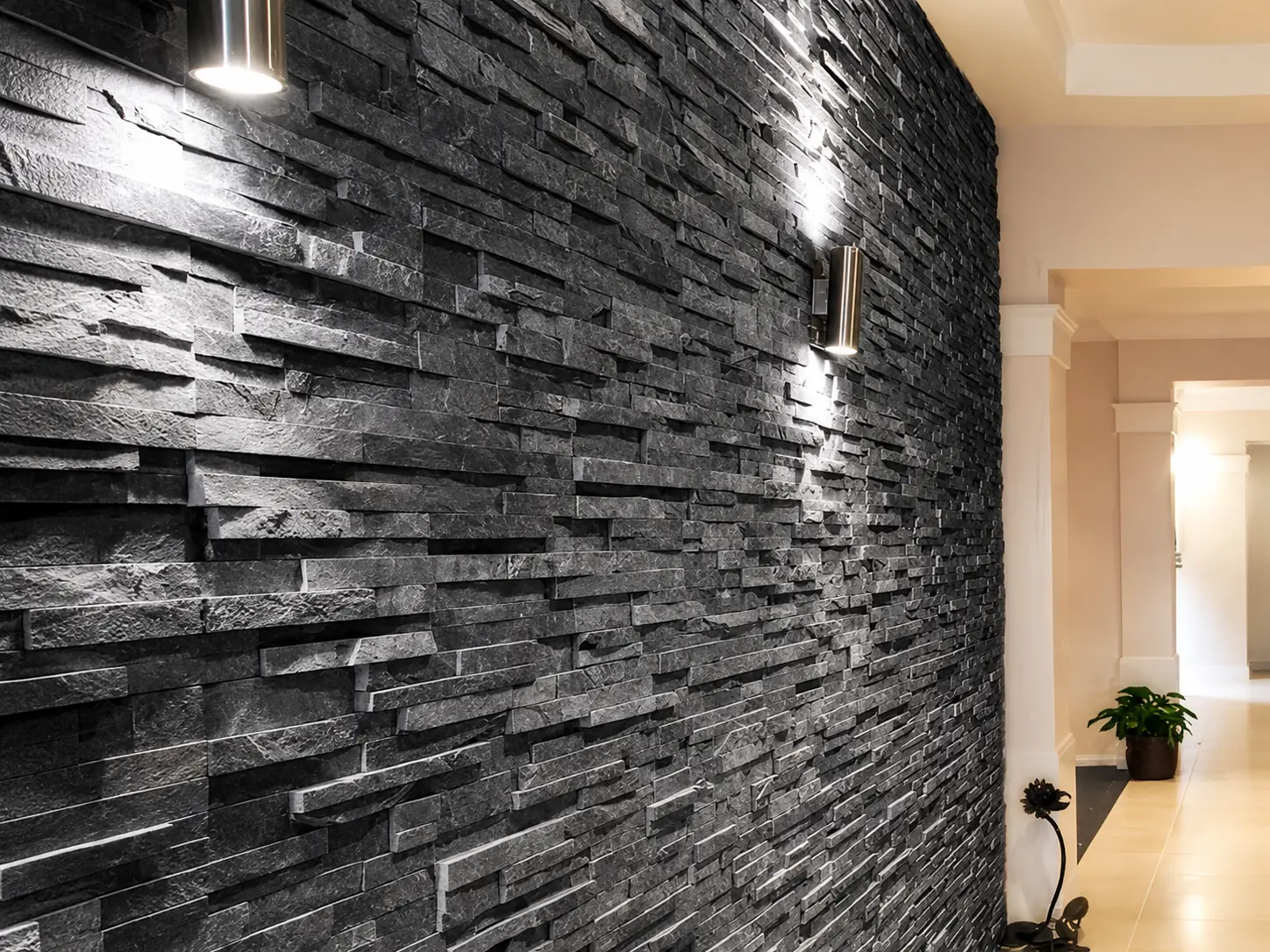 Dark stacked natural stone feature wall with architectural lighting