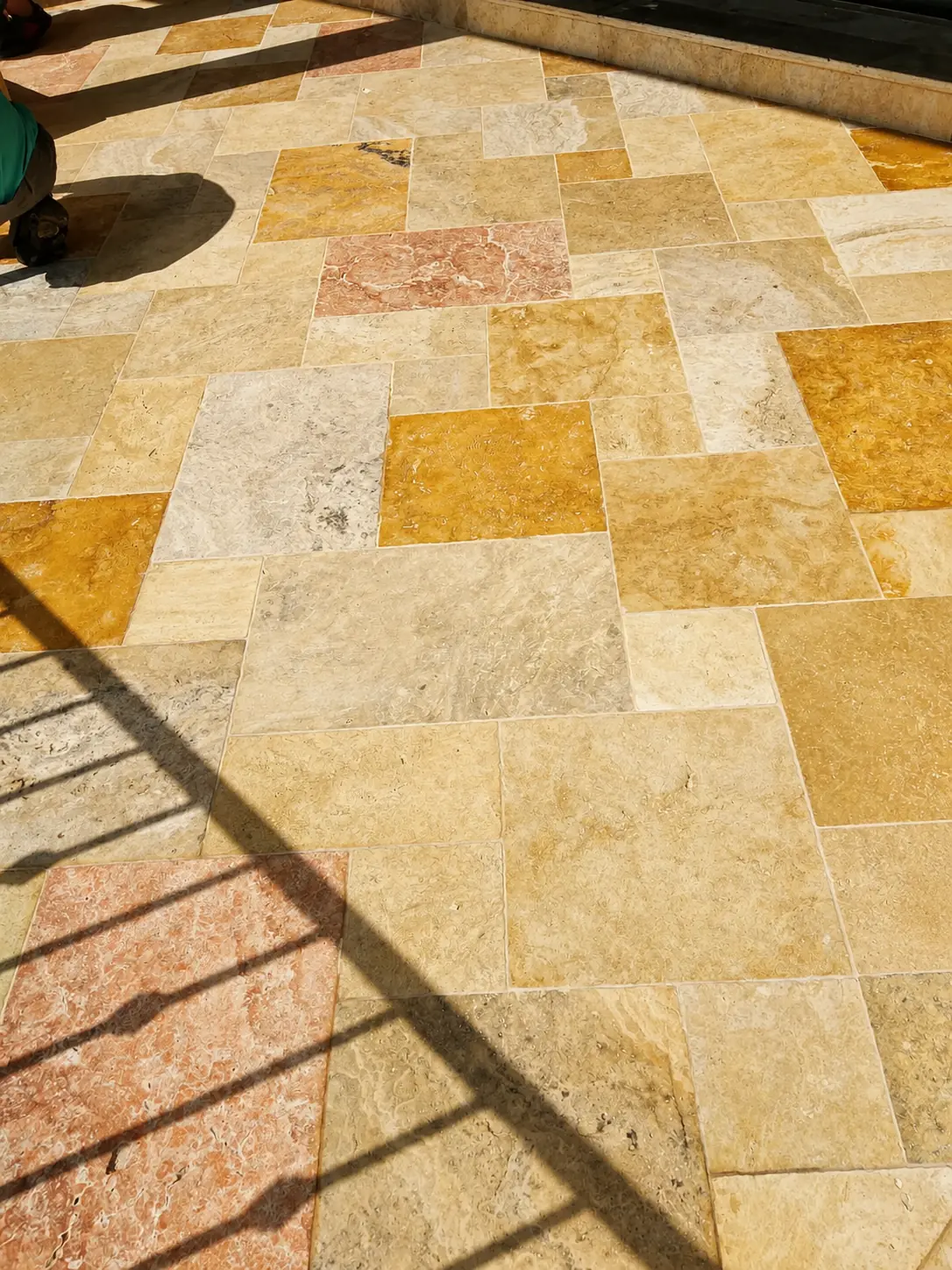 Warm-toned natural stone patio paving in direct sunlight