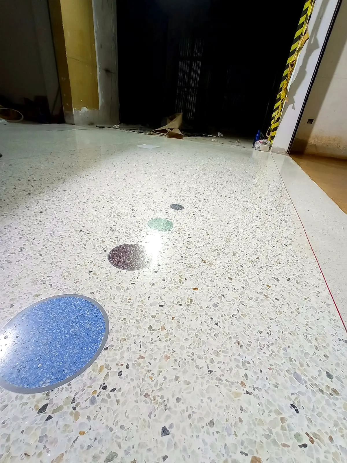 Light terrazzo floor with coloured aggregate circles and decorative details