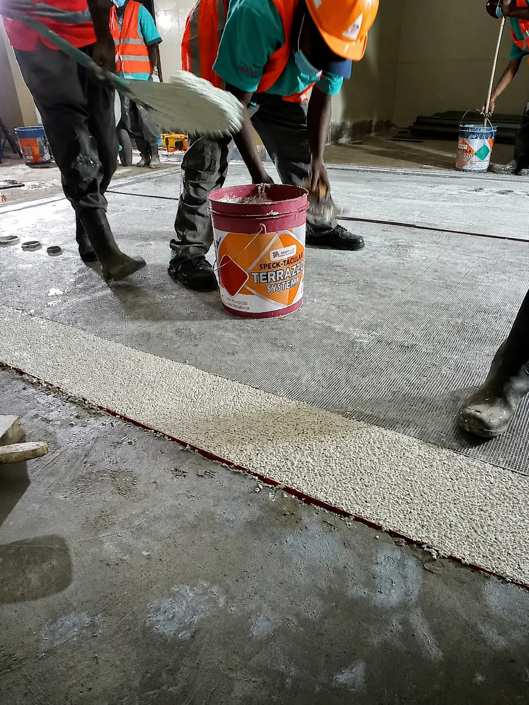 Sakafu crew preparing specialist floor materials inside an active work zone