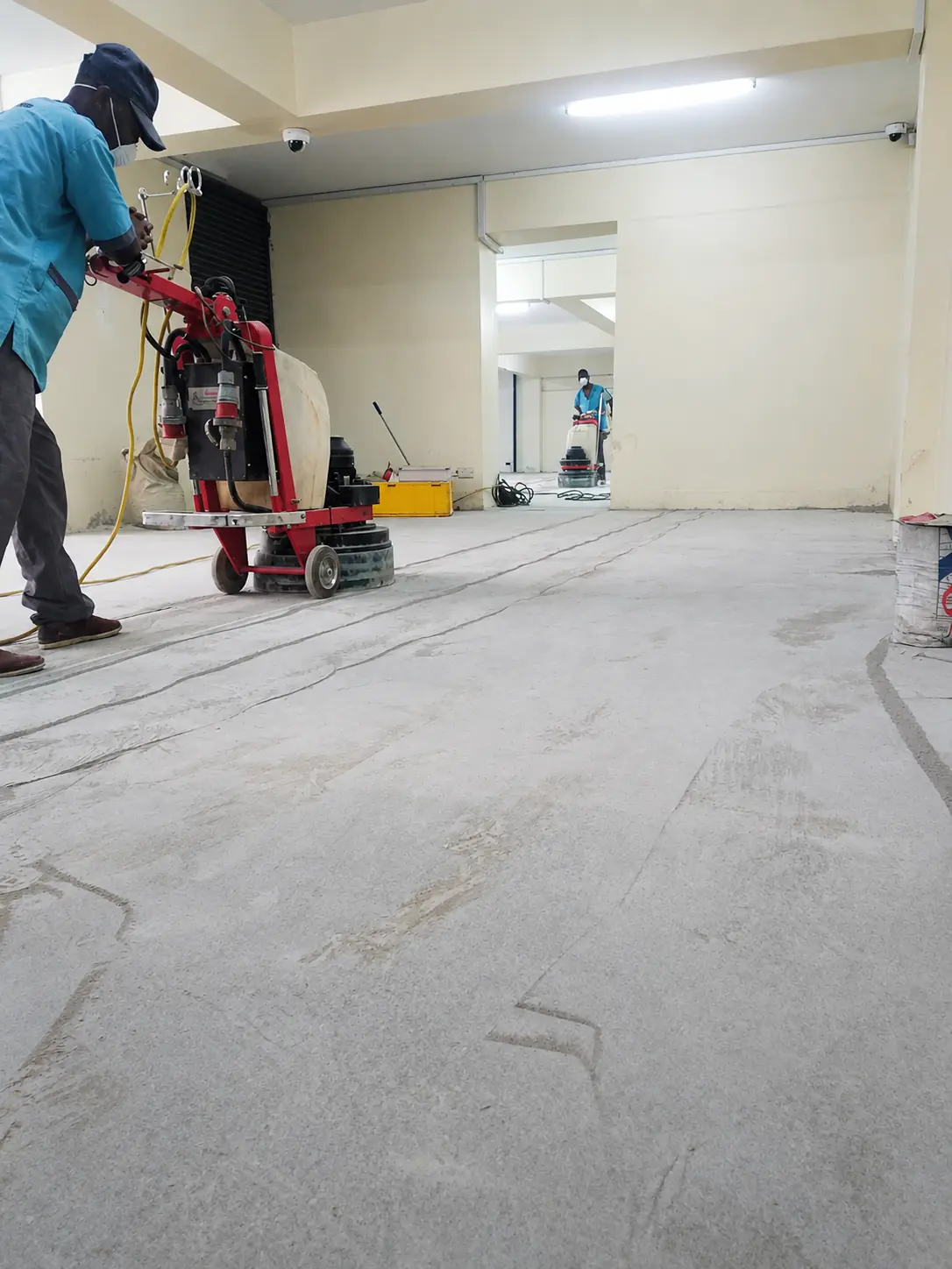 Sakafu specialist grinding and refining a concrete floor on site